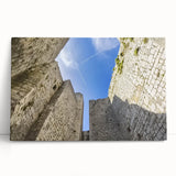 Stretched canvas artwork showcasing a picturesque landscape featuring a majestic castle surrounded by lush greenery and a clear blue sky, ideal for home decor.