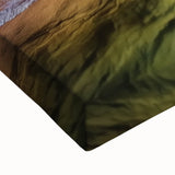 Close-up of a stretched canvas depicting a vibrant landscape of canyons with rich earthy tones, showcasing intricate details and textures ideal for home decor.