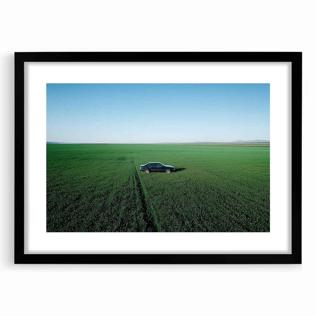 Black-framed landscape art print showcasing a serene countryside scene with vibrant greens and rolling hills, enhanced by a white mat, perfect for home decor.