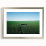 Framed silver landscape artwork depicting a serene countryside scene, featuring rolling hills and a clear blue sky, perfect for home decor enhancement.