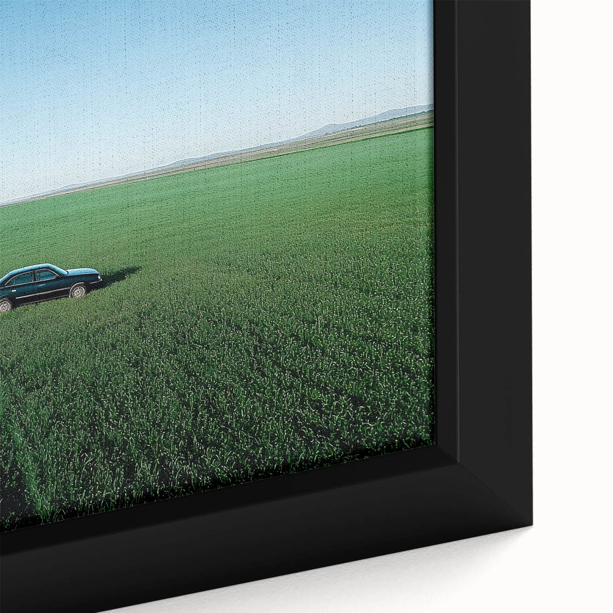 Close-up of a framed canvas print depicting a vibrant countryside landscape with rolling hills, lush greenery, and a serene blue sky, perfect for home decor.