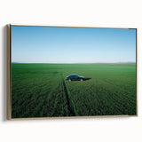 Framed canvas artwork depicting a serene countryside landscape with lush green fields and golden accents, showcasing a side view that highlights its elegant design.