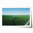 Rolled print showcasing a vibrant countryside landscape, featuring lush green fields and a clear blue sky, elegantly packaged in a protective cardboard tube for safe delivery.