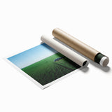 Landscape canvas print depicting a serene countryside scene with rolling hills, vibrant green fields, and a clear blue sky, rolled and packaged in a protective tube.