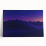 Stretched canvas artwork depicting a vibrant desert landscape with warm hues of orange and brown, elegantly leaning against a neutral wall, perfect for home decor.