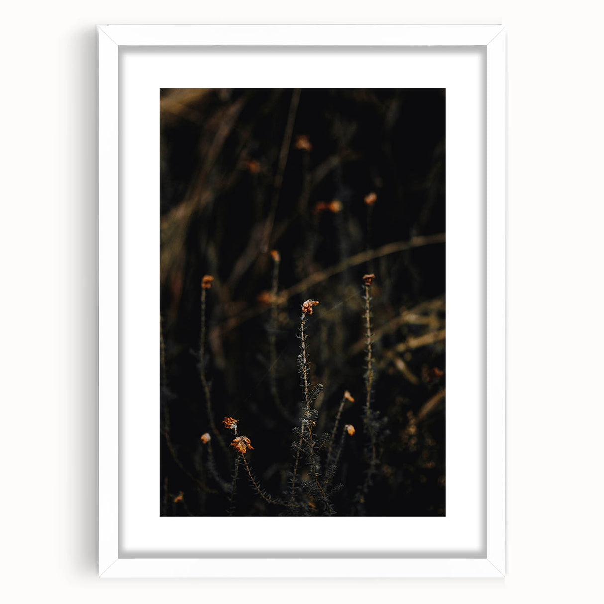 Abstract art print of autumn leaves in warm orange and red tones, framed in white, ideal for dining room decor.
