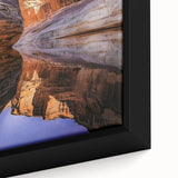 Close-up of a framed canvas artwork showcasing a stunning landscape with dramatic cliffs and vibrant colors, perfect for enhancing any home decor.