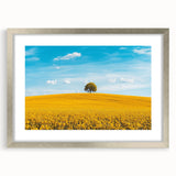 Framed landscape artwork of a serene countryside scene, featuring a silver mat and frame, ideal for home decor, showcasing vibrant colors and tranquil details.