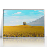 Framed acrylic artwork showcasing a serene countryside landscape with vibrant green fields and blue skies, elegantly displayed in a white frame, ideal for home decor.