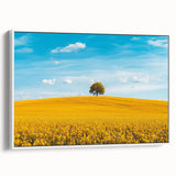 Framed canvas artwork depicting a serene countryside landscape with vibrant greens and soft blue skies, showcasing a peaceful rural scene ideal for home decor.