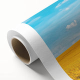 Rolled canvas showcasing a vibrant countryside landscape design, featuring lush green fields and a serene blue sky, neatly packaged in a protective cardboard tube.