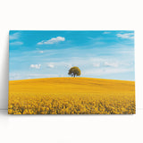 Stretched canvas artwork depicting a serene countryside landscape with vibrant green fields and a clear blue sky, ideal for home decor and nature enthusiasts.