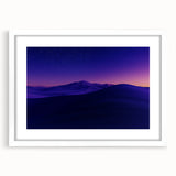 Framed desert landscape artwork showcasing vibrant hues of orange and blue, set in a sleek white mat, perfect for modern home decor.