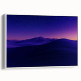 Framed canvas artwork depicting a serene desert landscape with warm tones of orange and beige, showcasing a white frame and side view for modern decor.