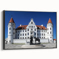 Framed canvas artwork depicting a stunning landscape with a majestic castle, set against a vibrant sunset backdrop, featuring a sleek black frame for an elegant display.