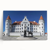 Stretched canvas artwork depicting a serene landscape with a majestic castle surrounded by lush greenery and a clear blue sky, ideal for home decor.