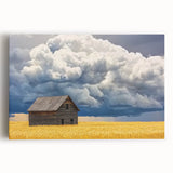 Stretched canvas artwork depicting a serene landscape scene with a rustic barn, vibrant greenery, and a clear blue sky, perfect for home decor.