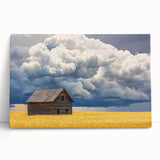 Stretched canvas artwork depicting a rustic barn landscape, featuring vibrant colors of green fields and a blue sky, ideal for farmhouse decor.