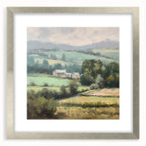 Framed landscape wall art depicting a serene countryside scene, featuring lush greenery and rolling hills, encased in a sleek silver frame with a white mat.