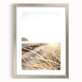 Textured abstract art print in vibrant orange and yellow shades, framed in silver, ideal for bedroom wall decor.