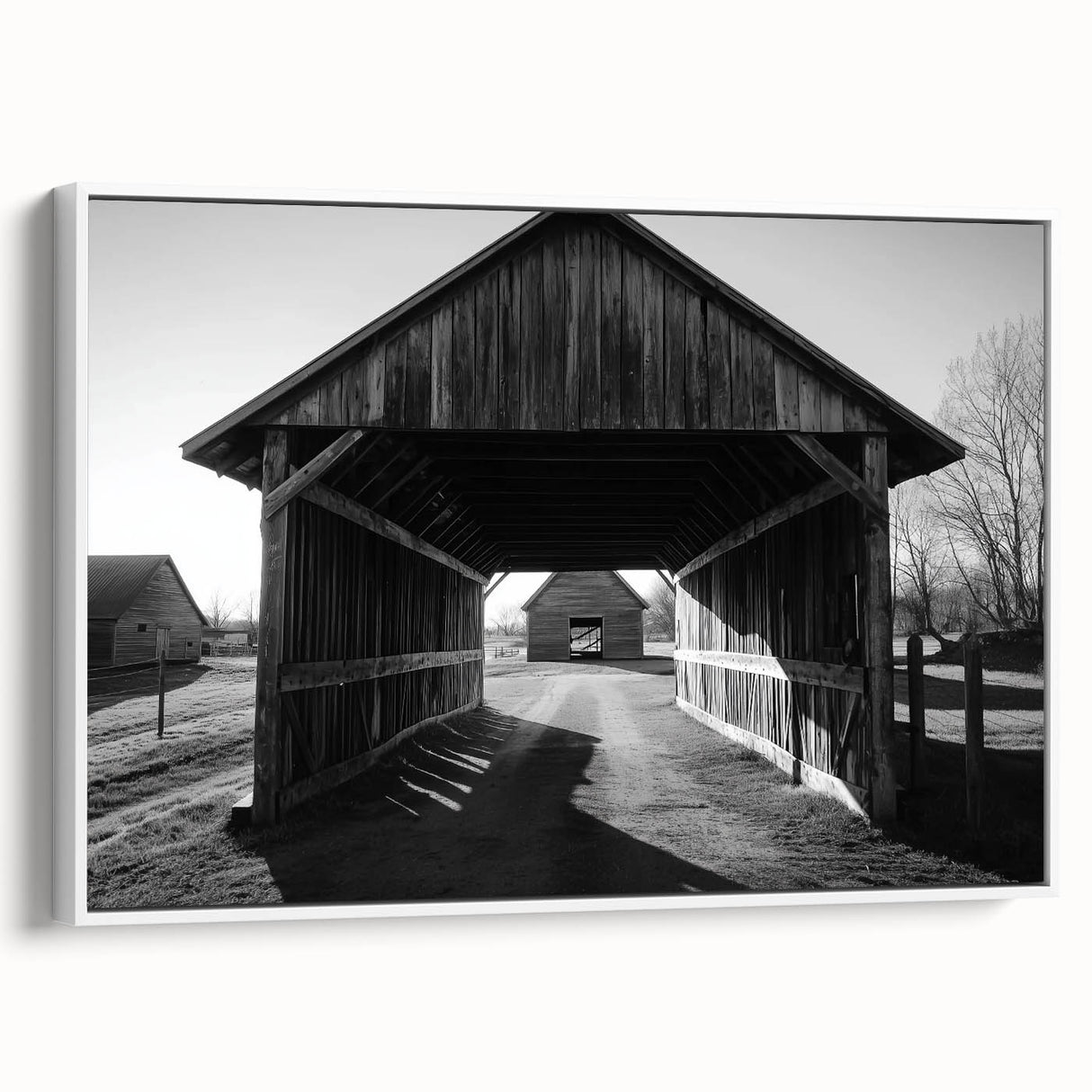 Framed landscape canvas featuring a serene barn scene with lush greenery, displayed from the side to highlight its elegant white frame and textured surface. Perfect for rustic home decor enthusiasts seeking to enhance their interior aesthetics.