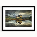 Framed landscape artwork depicting a majestic castle surrounded by lush greenery, showcased in a sleek black frame with a white mat, perfect for home decor.