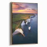 Framed canvas artwork depicting a stunning landscape of towering cliffs under a vibrant sunset, featuring a gold frame that enhances its elegance. Perfect for home decor.