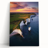 Stretched canvas artwork showcasing a dramatic cliff landscape with vibrant colors, leaning against a textured wall, perfect for home decor in nature-themed spaces.