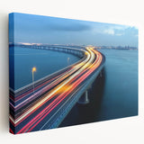 Stretched canvas artwork depicting a serene landscape featuring a bridge over a tranquil river, showcasing vibrant colors and intricate details, ideal for home decor.