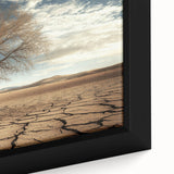 Close-up of a framed canvas showcasing a vibrant desert landscape, featuring warm hues of orange and yellow with intricate details of cacti and mountains, ideal for home decor.