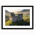 Elegant black-framed landscape artwork depicting a majestic castle surrounded by lush greenery, featuring a white mat for an enhanced presentation. Perfect for home decor.