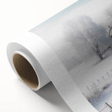 Winter scene with soft snowfall and bare trees on rolled canvas, in muted gray and blue tones, ideal for nursery wall art.