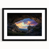 Framed landscape artwork depicting a serene cave scene with rich earthy tones, set in a sleek black frame with a mat, perfect for modern home decor.