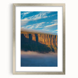 Framed landscape artwork depicting dramatic cliffs, featuring a silver mat and frame, perfect for enhancing modern decor and bringing nature indoors.