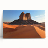 Desert landscape stretched canvas art featuring warm hues of orange, yellow, and brown, elegantly leaning against a textured wall, perfect for home decor.