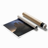 Rolled print showcasing a vibrant landscape featuring a majestic castle surrounded by lush greenery, elegantly packaged in a protective cardboard tube for shipping. This artwork adds a touch of charm to any decor.