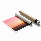 Rolled print of a serene countryside landscape, showcasing lush green hills and a clear blue sky, elegantly packaged in a protective cardboard tube for easy transport.