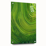 Vibrant acrylic glass landscape artwork depicting rolling green fields and a clear blue sky, showcased from a side view with decorative pins for secure mounting.