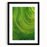 Framed landscape artwork in a black mat and frame, showcasing vibrant green fields under a clear blue sky, ideal for home decor and interior design.