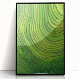 Framed acrylic artwork showcasing a vibrant landscape of lush green fields under a clear blue sky, presented in a sleek black frame, perfect for home decor.