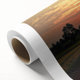 Rolled canvas print showcasing a serene countryside landscape with vibrant green fields and rolling hills, elegantly packaged in a protective cardboard tube for delivery.