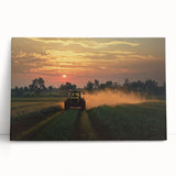Stretched canvas artwork depicting a serene countryside landscape with rolling hills and a vibrant sunset, leaning against a textured wall for display.