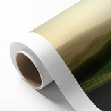 Vibrant rolled canvas displaying a serene landscape with lush green fields and a clear blue sky, elegantly packaged in a protective cardboard tube for safe shipping.