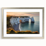 Silver-framed landscape print showcasing dramatic cliffs and serene skies, mounted with a white mat for a polished look, ideal for enhancing home decor.