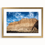 Framed landscape artwork depicting canyons with a gold mat, showcasing vibrant colors and intricate details, ideal for home decor or office settings.
