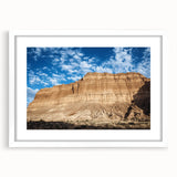 Landscape art print of a canyon scene featuring vibrant orange and red hues, set in a sleek white frame with a mat, ideal for home decor or office enhancement.
