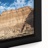 Close-up of a framed canvas artwork depicting a vibrant landscape of canyons, showcasing rich earthy tones and intricate details, perfect for enhancing home decor.