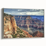 Framed canvas artwork showcasing a stunning landscape of canyons in rich earth tones, set in a sleek silver frame, perfect for enhancing modern home decor.