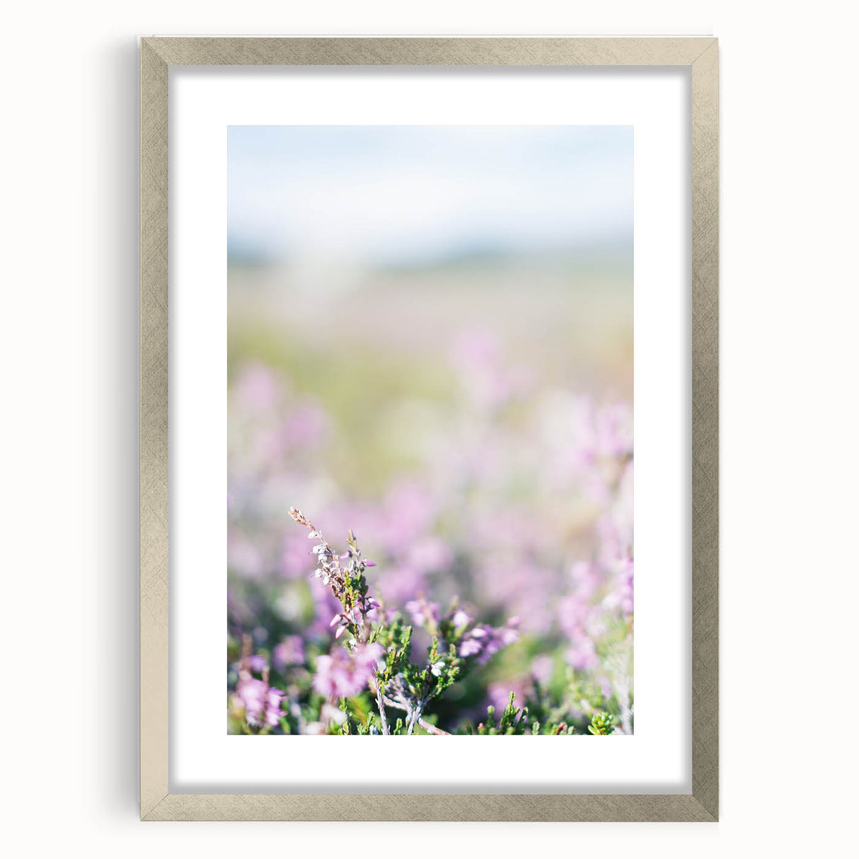Textured art print of abstract spring-themed imagery in soft green and yellow tones, framed in silver, ideal for bedroom art.