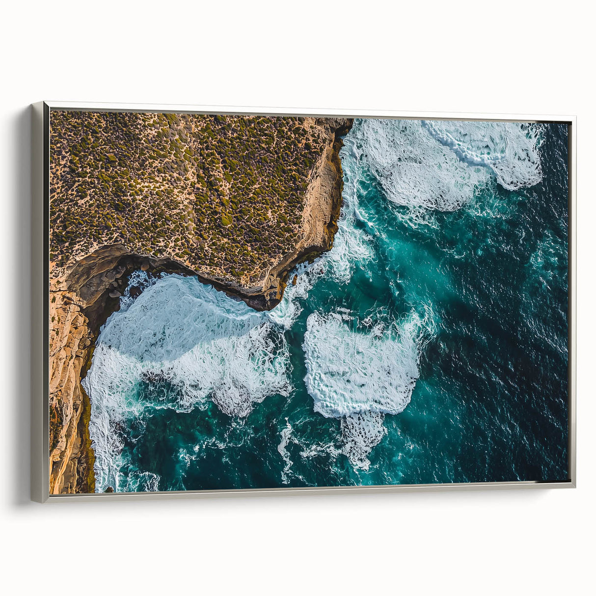 Framed canvas artwork depicting dramatic cliffs and landscapes, featuring a sleek silver frame that enhances the natural scenery, ideal for modern home decor.